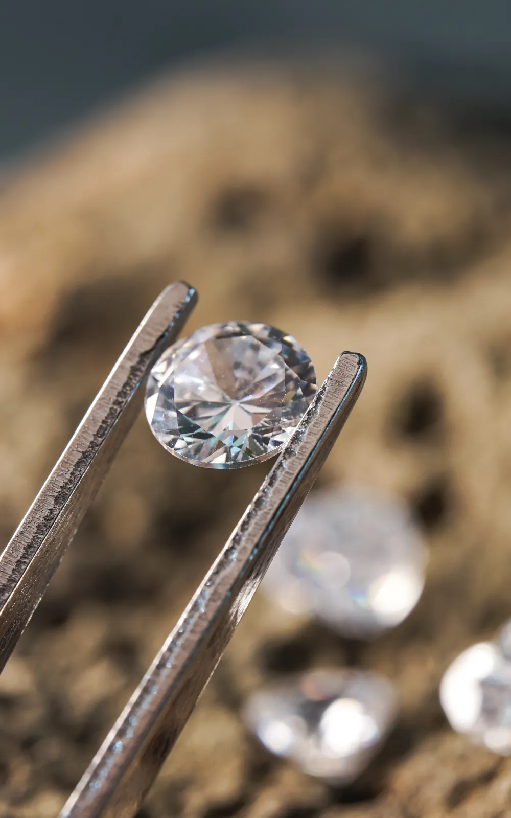 Ein 3-Karat-Diamant wird mit einer Pinzette über einem natürlichen Steinuntergrund gehalten und zeigt sein präzises Facettenspiel