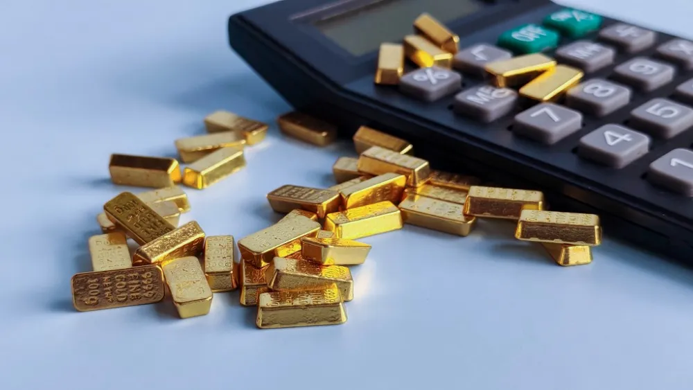 Goldbarren neben Taschenrechner zur Berechnung des Goldwerts